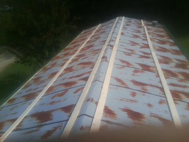 Rusted metal roof panels with new wood purlins before replacement — Storm Damage Roof Repair in Summer Lake by Roofing Brothers